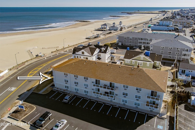 bird's eye view with a water view and a beach view