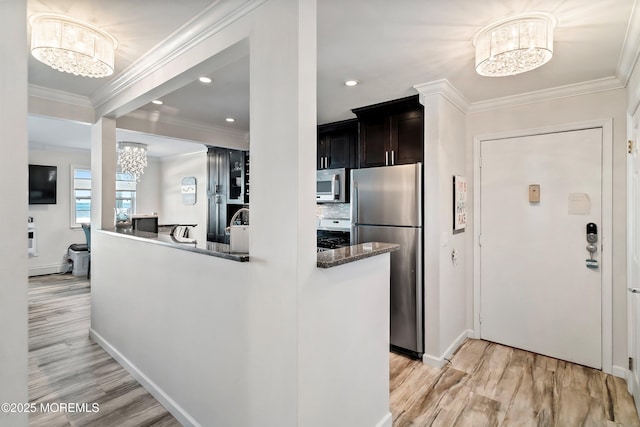 kitchen with a notable chandelier, light hardwood / wood-style flooring, stainless steel appliances, and kitchen peninsula