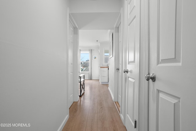 hallway featuring baseboards and light wood-style floors