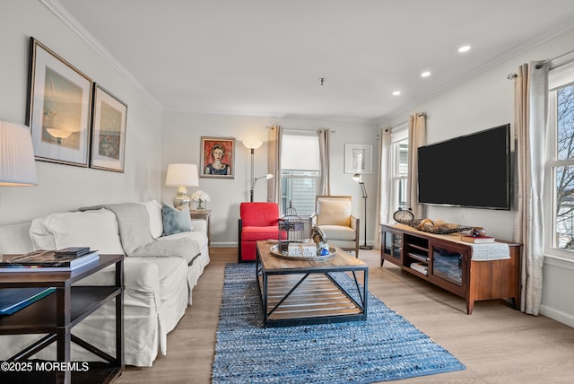 living area with light wood-type flooring, crown molding, baseboards, and recessed lighting