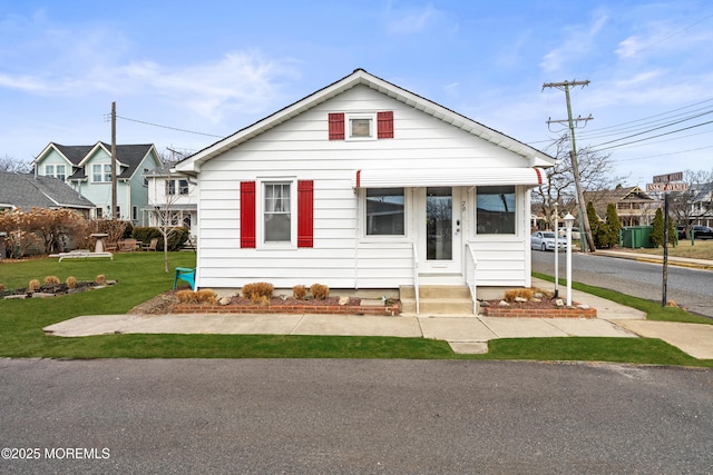 bungalow-style home with a front yard