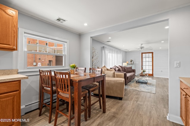 dining room with recessed lighting, light wood-type flooring, visible vents, and ornamental molding