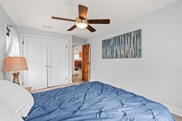 bedroom featuring baseboards, visible vents, multiple windows, and a closet