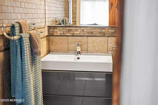 bathroom with tile walls, tasteful backsplash, and a sink