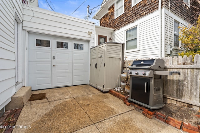 view of patio with a grill, concrete driveway, and a garage