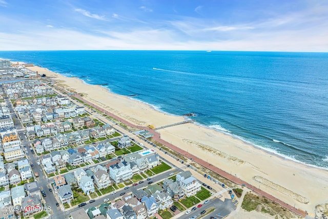 drone / aerial view featuring a water view and a view of the beach