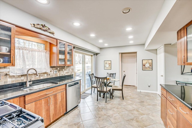 kitchen featuring tasteful backsplash, dishwasher, sink, and range with gas stovetop