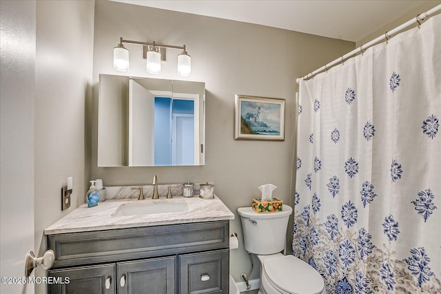 bathroom featuring vanity, curtained shower, and toilet