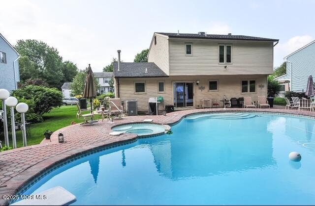 view of pool featuring an in ground hot tub, a grill, and a patio area