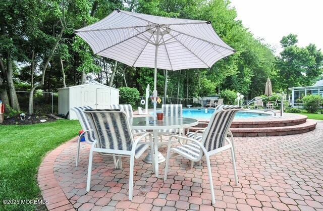 view of patio with a community pool and a shed