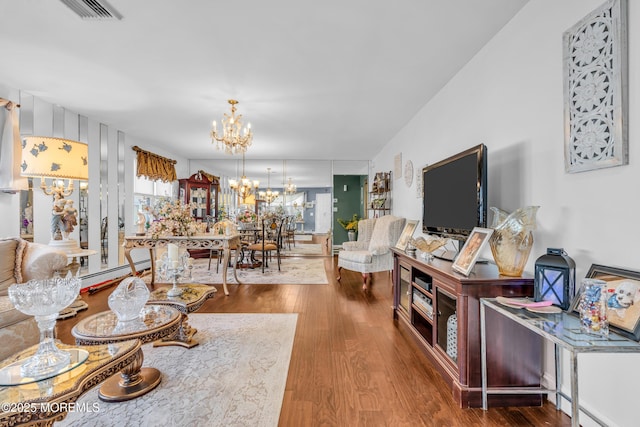 living room with wood-type flooring, a baseboard radiator, and a chandelier