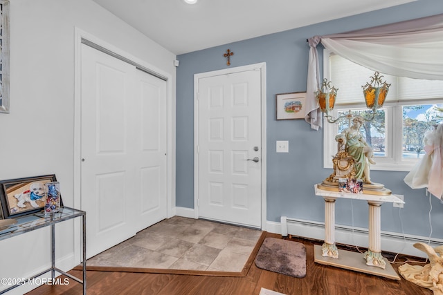 foyer with baseboard heating and light hardwood / wood-style floors