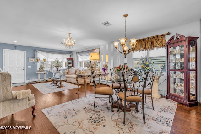 dining space featuring a baseboard radiator, a chandelier, and hardwood / wood-style floors