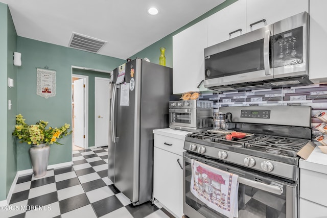 kitchen featuring appliances with stainless steel finishes, white cabinets, and backsplash