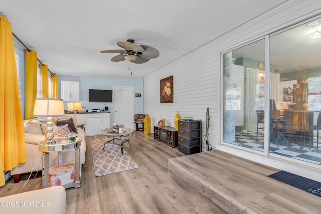 living room featuring ceiling fan and light hardwood / wood-style flooring