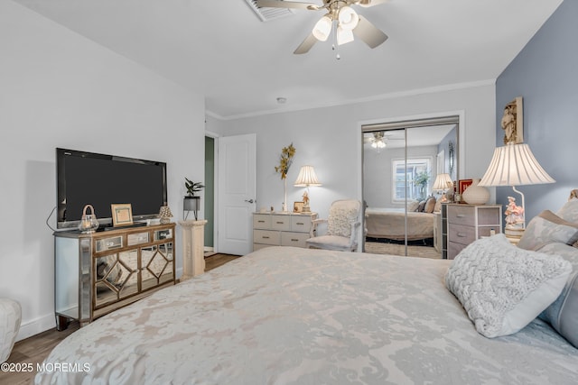 bedroom with crown molding, wood-type flooring, a closet, and ceiling fan