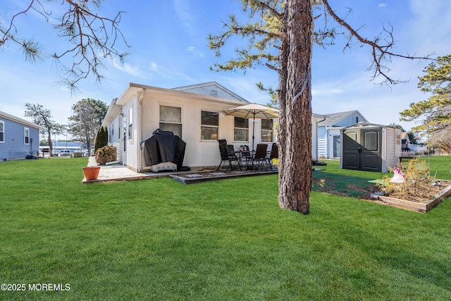 rear view of property featuring a yard and a storage shed