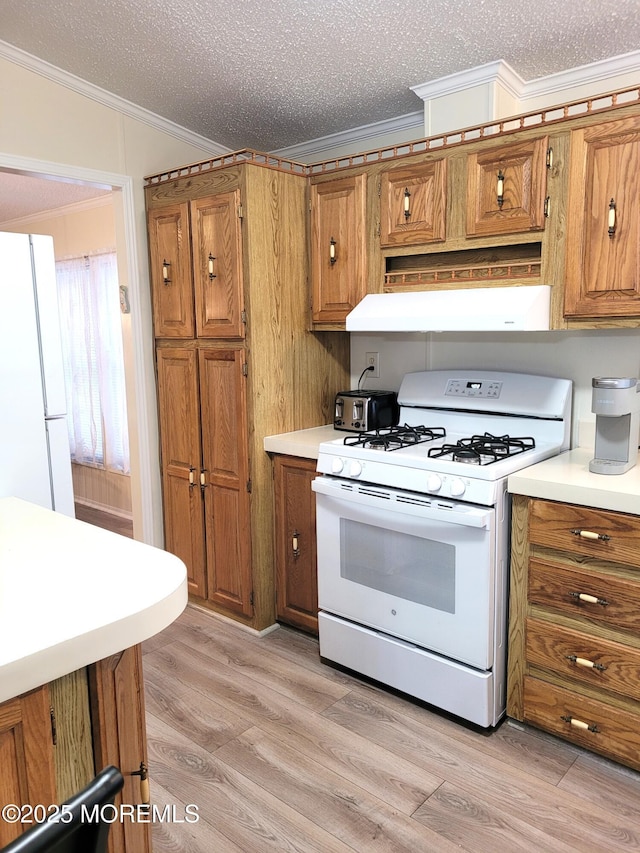 kitchen featuring white appliances, ornamental molding, a textured ceiling, and light wood-type flooring