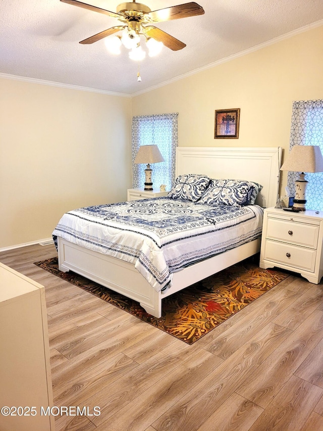 bedroom featuring vaulted ceiling, light wood-type flooring, ceiling fan, crown molding, and a textured ceiling