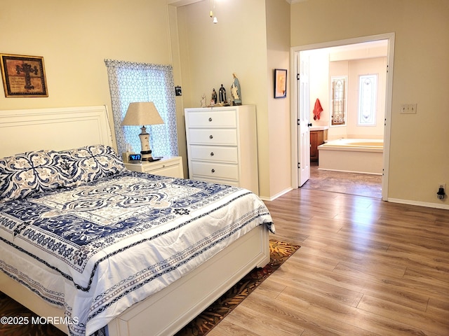 bedroom featuring connected bathroom and hardwood / wood-style floors