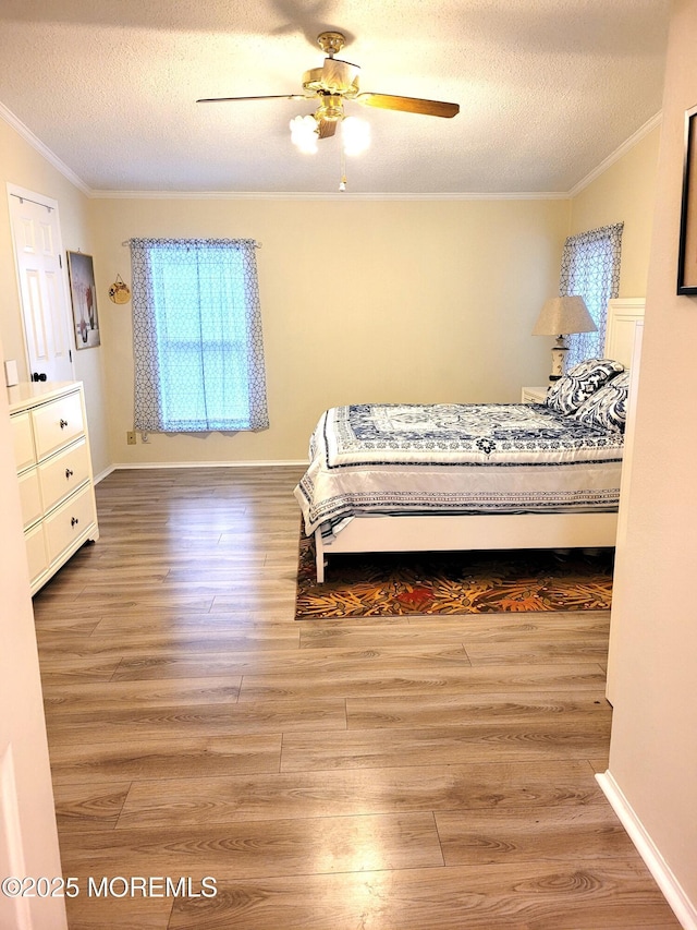 bedroom featuring crown molding, ceiling fan, hardwood / wood-style floors, and a textured ceiling