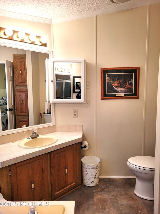 bathroom with vanity, toilet, and a textured ceiling