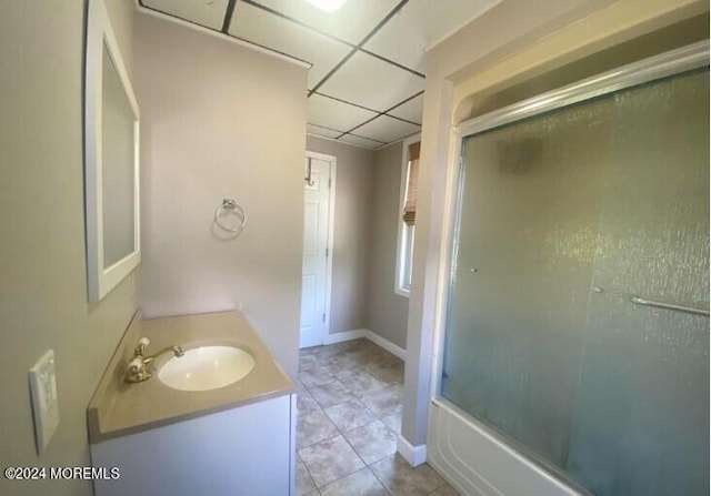 bathroom featuring vanity, tile patterned flooring, a paneled ceiling, and shower / bath combination with glass door