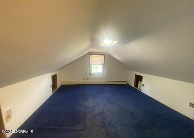 additional living space featuring vaulted ceiling, a baseboard heating unit, and dark carpet