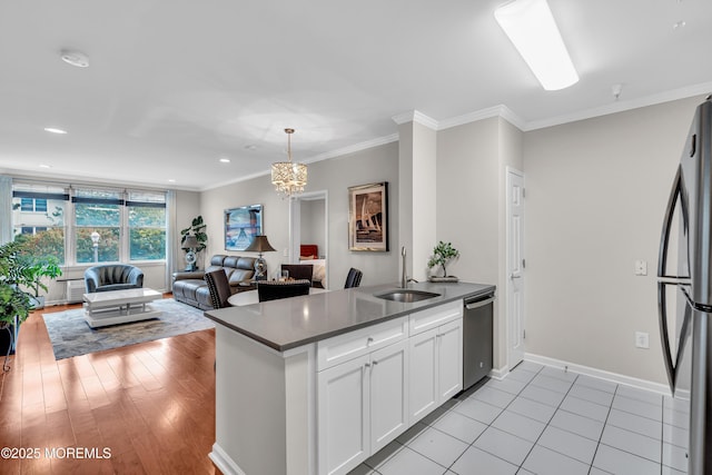 kitchen featuring sink, white cabinetry, ornamental molding, appliances with stainless steel finishes, and pendant lighting