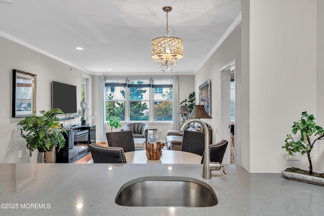 kitchen with hanging light fixtures, crown molding, sink, and an inviting chandelier