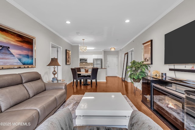 living room with ornamental molding, light hardwood / wood-style floors, and a chandelier