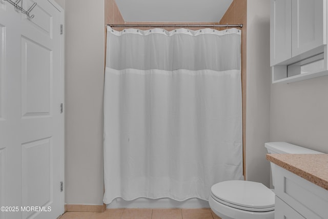 full bathroom featuring shower / tub combo with curtain, tile patterned floors, toilet, and vanity