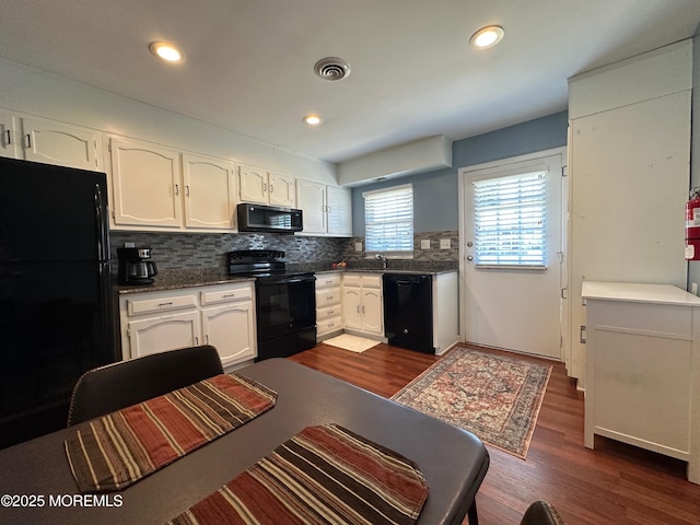 kitchen featuring white cabinetry, decorative backsplash, dark hardwood / wood-style flooring, and black appliances