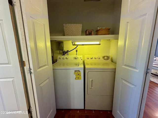 washroom with washing machine and dryer and dark wood-type flooring