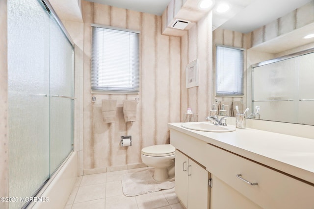 full bathroom featuring combined bath / shower with glass door, vanity, toilet, and tile patterned floors