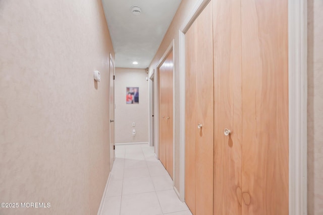 hall with light tile patterned floors and baseboards