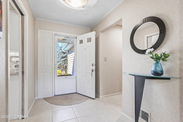 entrance foyer featuring light tile patterned floors, baseboards, visible vents, and crown molding