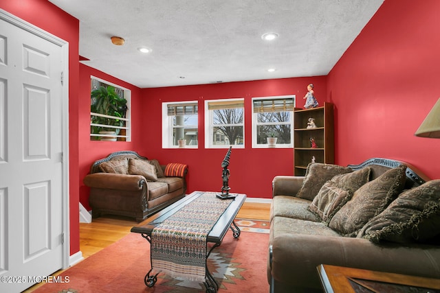 living room with light wood-type flooring and a textured ceiling