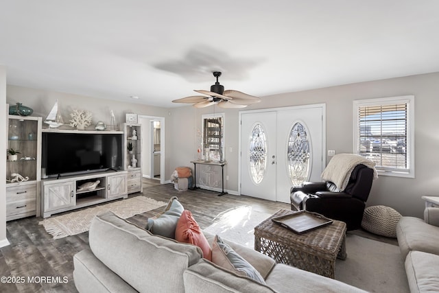 living area with dark wood-style floors, baseboards, and ceiling fan