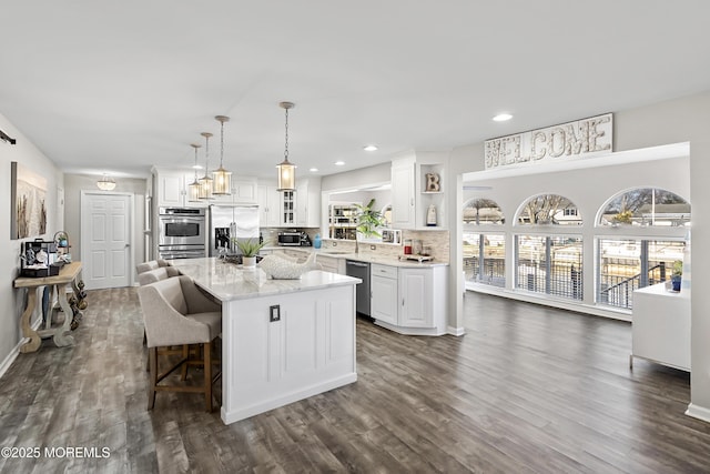 kitchen featuring open shelves, stainless steel appliances, white cabinets, and a center island