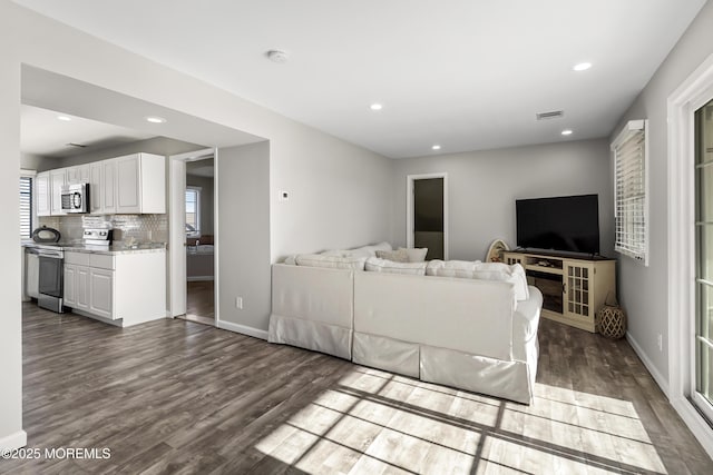 living area with visible vents, recessed lighting, baseboards, and wood finished floors