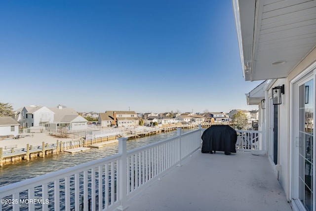 balcony with a residential view and a water view