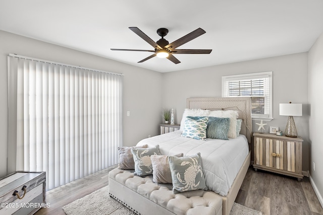 bedroom featuring wood finished floors, baseboards, and ceiling fan