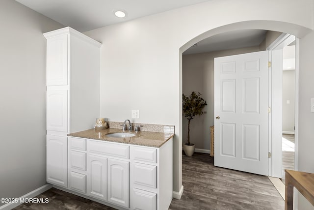 bathroom featuring vanity, recessed lighting, wood finished floors, and baseboards