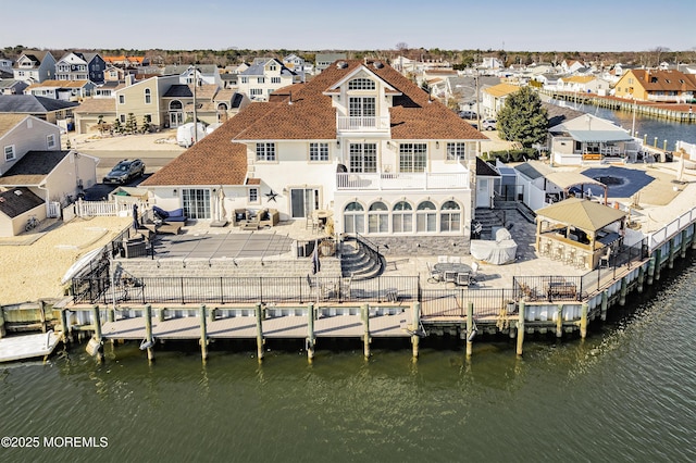 rear view of house with a water view, a fenced backyard, a residential view, a balcony, and a patio area