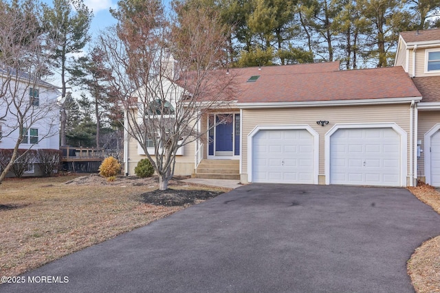 view of front facade with a garage, roof with shingles, and driveway