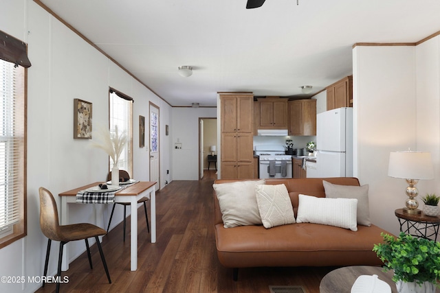 living area with dark wood-style floors, ceiling fan, and crown molding