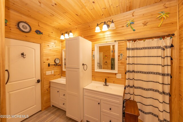 bathroom with vanity, wooden ceiling, and wooden walls