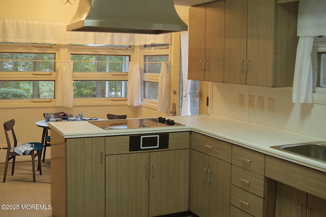 kitchen featuring range hood, a peninsula, cooktop, light countertops, and light tile patterned floors