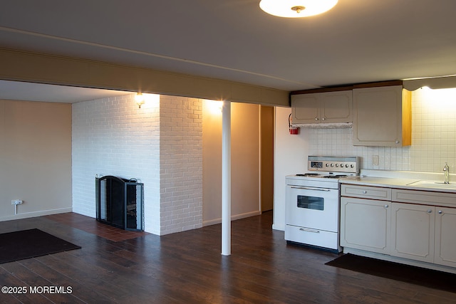 kitchen featuring electric stove, dark wood-style floors, baseboards, and a brick fireplace